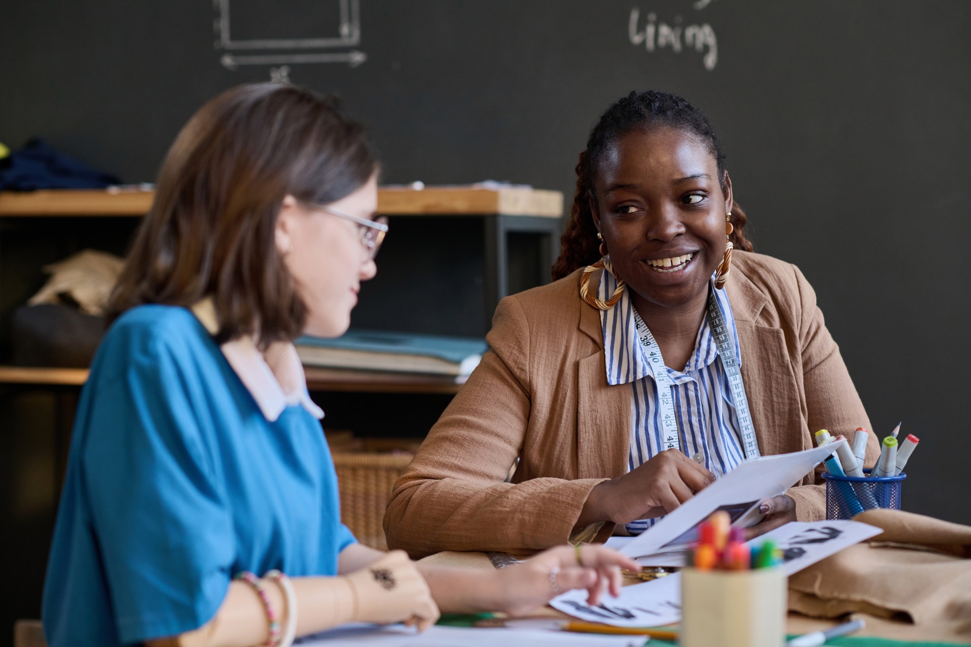 Teacher talking to student during sewing class