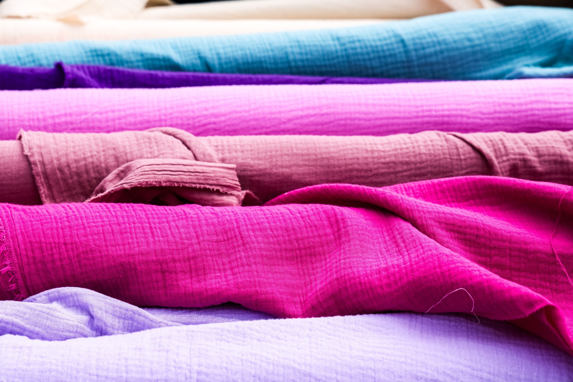 Colorful double gauze fabric rolls showing texture and colors